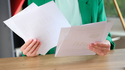 Obraz premium Woman holding financial documents with charts and graphs