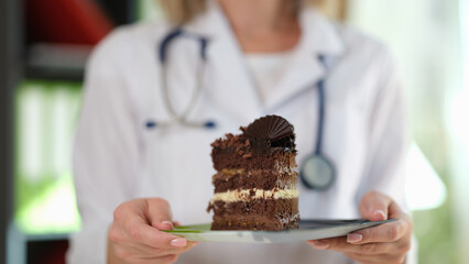Woman nutritionist holding in hands piece of chocolate cake