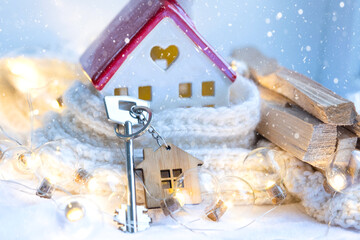 Key to the house with a keychain on a cozy home with a Christmas decor. A gift for New Year,...
