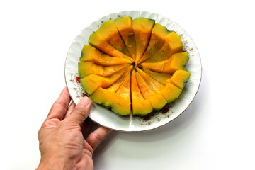 Boiled pumpkin, cut into pieces and put on a plate on a white background. Can do both savory and...