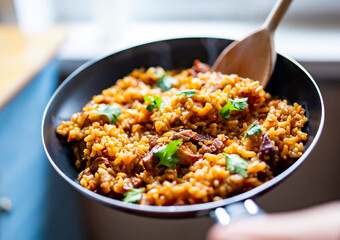 cooking tasty rice, meat and vegetable in pan on kitchen