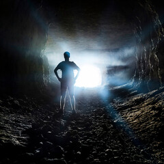 Obraz premium The man is standing at the entrance to the cave.
