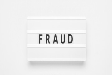 Lightbox with word fraud on white background. Business concept.