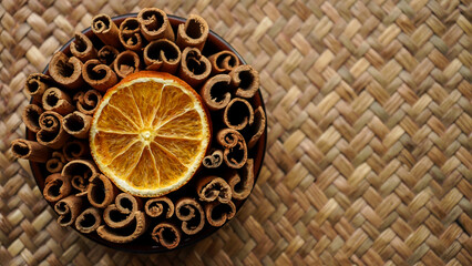 bowl with cinnamon sticks and dried orange slices,  top view        