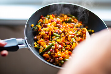 cooking tasty vegetable mix with corn, pea, beans in pan on kitchen