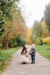 Fototapeta premium Mom and son walking and having fun together in the autumn park.