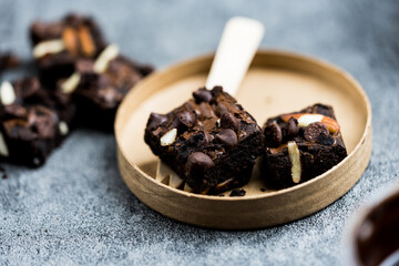 Chocolate brownies are cakes made from eggs, butter, flour and cocoa powder in the oven and topped with chocolate chips and almonds slice, The texture is crunchy on the outside but soft on the inside