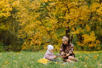 Mom and son walking and having fun together in the autumn park.