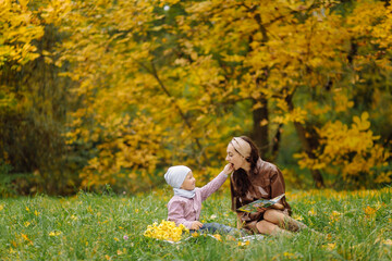 Mom and son walking and having fun together in the autumn park.