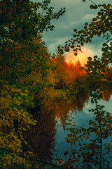 Sunrise against the background of red clouds of a forest lake - 549202233