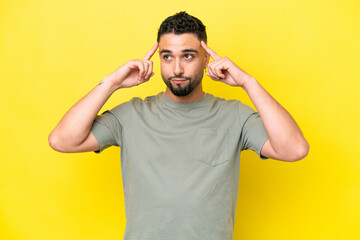 Young Arab handsome man isolated on yellow background having doubts and thinking