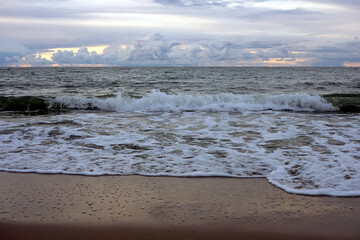 Landscape overlooking the sea in the evening with stormy clouds at far and sea waves washing the...