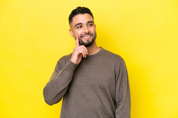 Young Arab handsome man isolated on yellow background thinking an idea while looking up