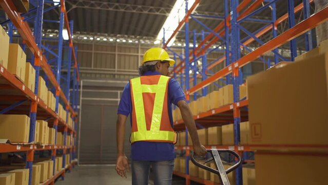 Portrait of Indian worker working in large warehouse retail store industry. Rack of stock storage. Interior of cargo in ecommerce and logistic concept. Depot. People lifestyle. Shipment service.