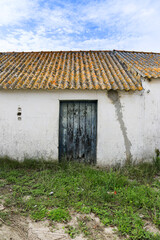 Fototapeta na wymiar Old blue wooden door and uralite roof