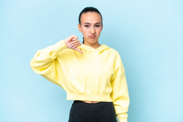 Young Arab woman isolated on blue background showing thumb down with negative expression