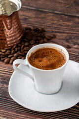 Turkish coffee in classic coffee cup with water and Turkish delight on wooden table