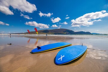Two blue surfing boards on sandy beach in tropical island under blue sky, concept of vacation