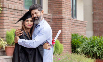 Indian university female student and her father celebrating graduation degree convocation ceremony
