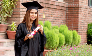 Young indian graduated girl holding his graduation degree convocation ceremony.