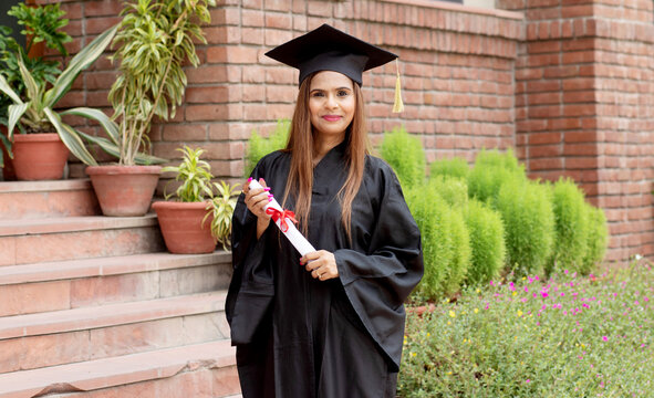 Young indian graduated girl holding his graduation degree convocation ceremony.