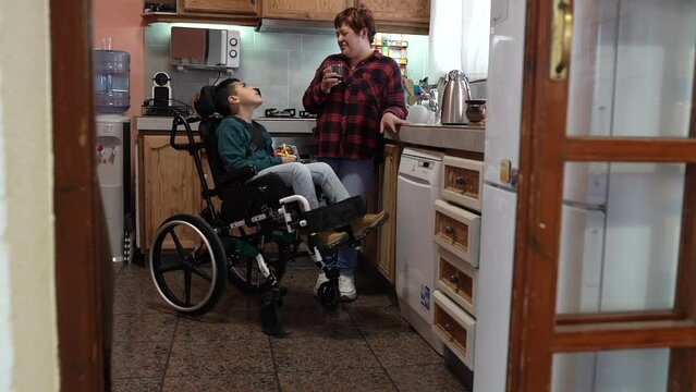 mother with child in a wheelchair with a disability in the kitchen