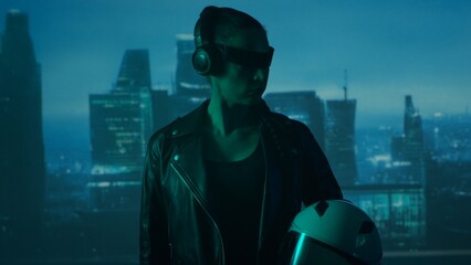 Portrait of cyberpunk girl with a smartphone in a glasses and headphones. Beautiful young woman on...
