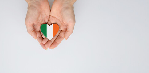 The national flag of Ireland of arms in female hands. Flat lay, copy space.