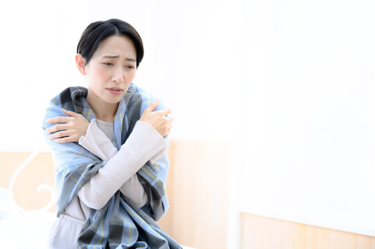 ちょっと風邪ひいたいかな～と寒がる女性右にコピースペースあり