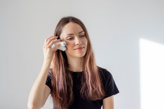 Happy woman doing facial microcurrents. Facial massage at home with a device with currents.