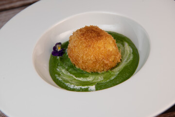 Recipe Breaded soft-boiled eggs and creamed spinach with parmesan. High quality photo