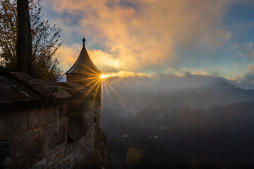 Turm der Festung Königstein im Gegenlicht bei Sonnenaufgang mit Nebel im Tal im Herbst