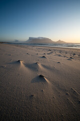 Steine im Sand und Blick auf den Tafelberg.