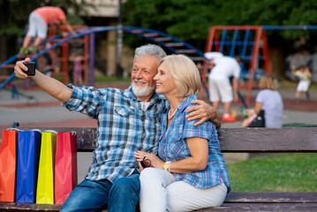 Smiling senior couple taking selfie in a park