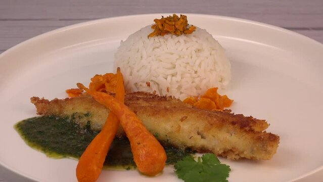 Recipe for Hake fillet breaded with panko, rice, carrot chips and coriander sauce. High quality photo