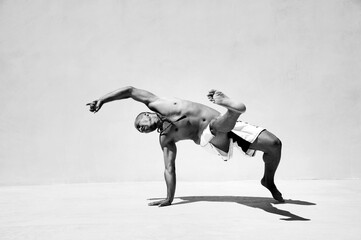 Athletic man performing acrobatic and animal like movement patterns for fitness. 