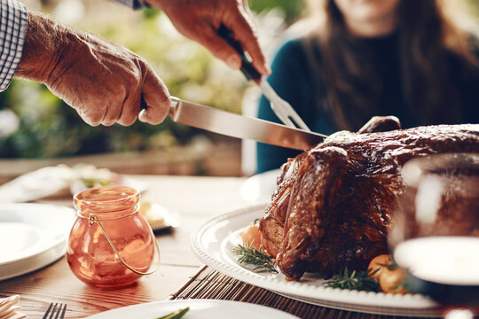 Turkey, Thanksgiving And Chicken Cut By Hands At A Table For A Family At A Home Or House Gathering Celebration. Party, Zoom And Man With Knife Cutting Food Or Meat To Celebrate And Eat With Friends