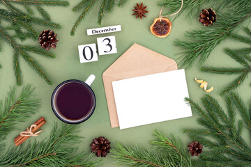 December 3. Calendar date, white blank with craft envelope, cup of tea and natural decor on green background. Hello winter. Template for your design, greeting card
