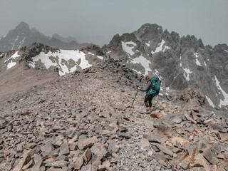 Woman hiking the long distance hike in Corsica called the GR20. A long hike with a heavy backpack. Hiking for two weeks with the most incredible views over the mountains. 