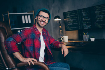 Photo of happy smiling freelancer wear hat glasses creating block chain modern gadget indoors...