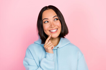 Fototapeta premium Photo of dreamy sweet lady wear blue hoodie finger chin looking empty space isolated pink color background