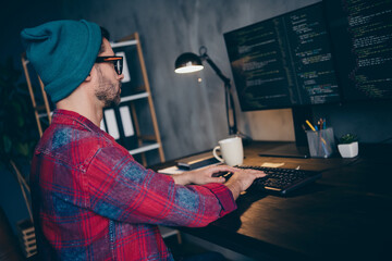 Photo of busy clever coder dressed hat glasses writing javascript modern gadget indoors workplace...