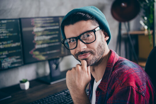 Photo of clever thoughtful freelancer wear hat glasses hand chin working home based indoors workplace workstation loft