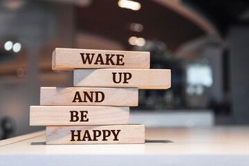 Wooden blocks with words 'Wake Up And Be Happy'.