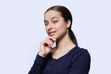 Portrait of teenager girl looking at camera on white background