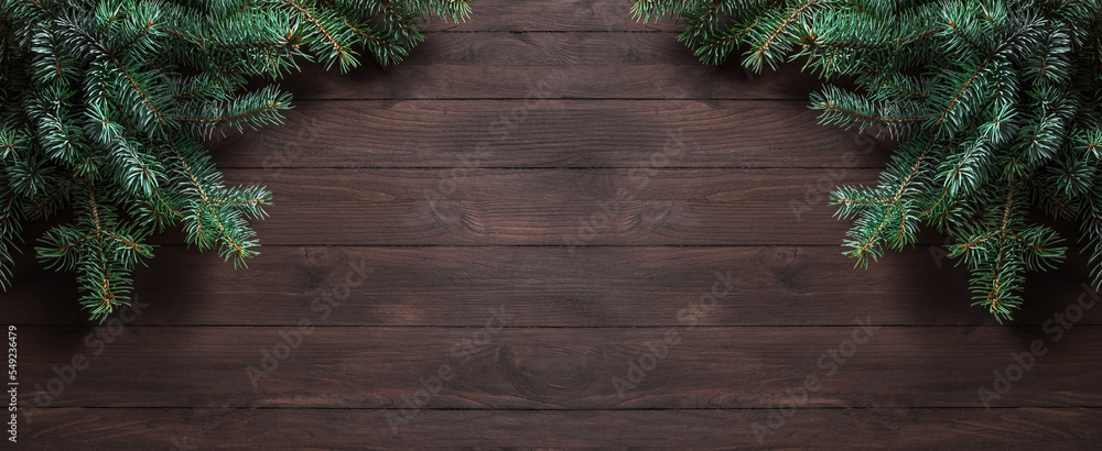 Wall mural Christmas wooden background with pine branches