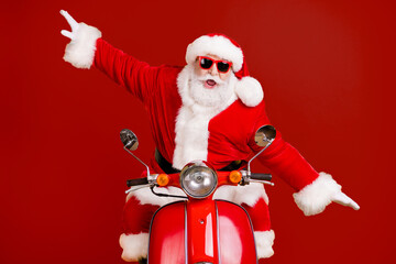 Portrait of his he nice childish playful cheerful cheery Santa riding moped fooling having fun like plane fly air flight isolated bright vivid shine vibrant yellow color background
