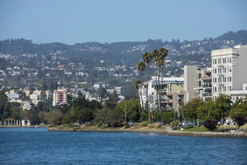 Afternoon view of the lake shore skyline of Lake Merritt in Oakland, California, USA. - obrazy, fototapety, plakaty