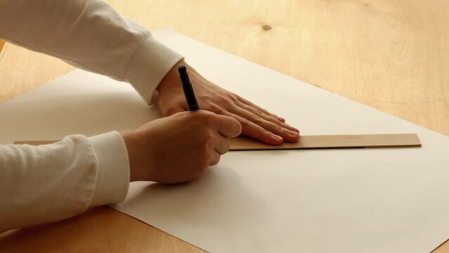 Young man drawing line on a white paper with using a marker pen and a ruler. Pavel, my hands and paper. Date of shooting day 8 October 2022 year, MSK time. This video was filmed in Russia.