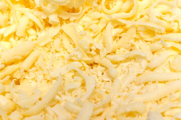 grated parmesan cheese texture. cheese covering the whole frame. details of grated cheese.
